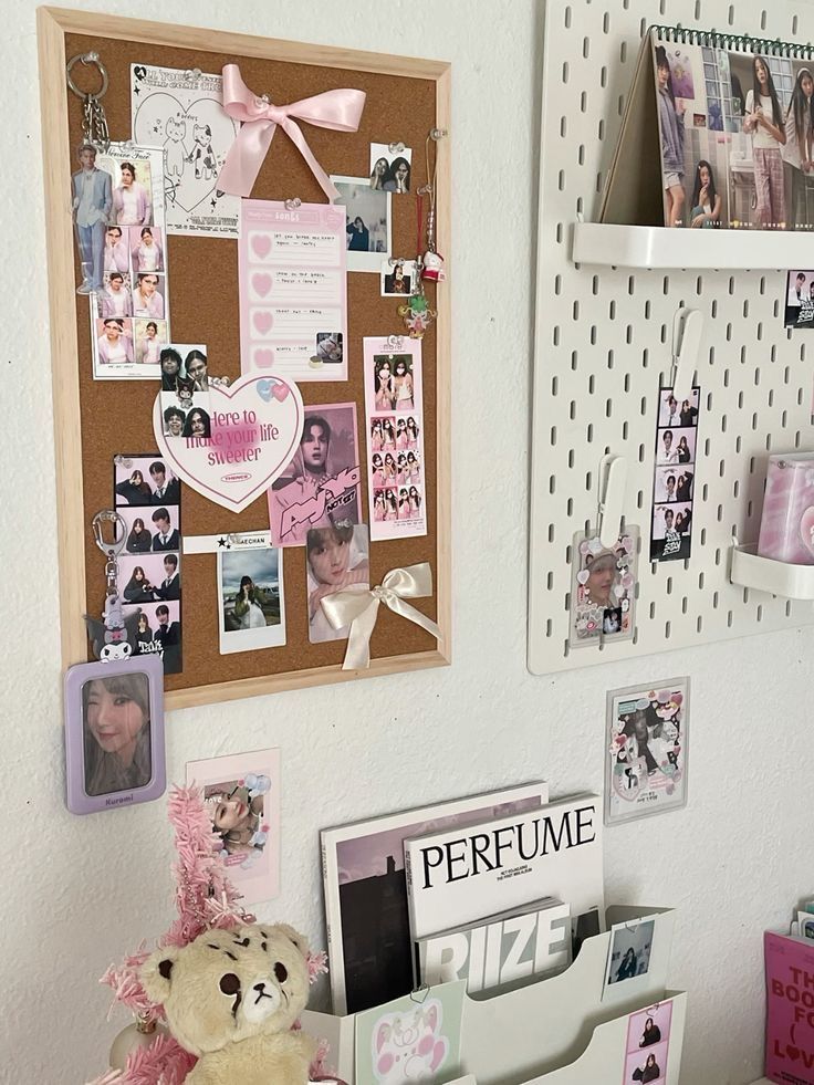 a teddy bear is sitting on a desk with many photos and magnets attached to the wall