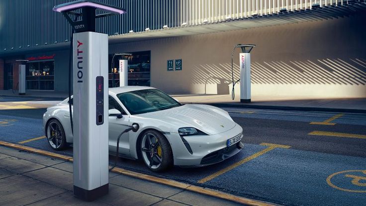 a white car is parked next to an electric charging station