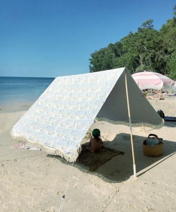 a white tent sitting on top of a sandy beach