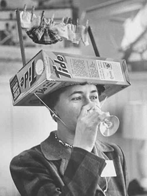 a woman with a box on her head drinking from a wine glass, and the caption reads it appears that years of doing too much laundry