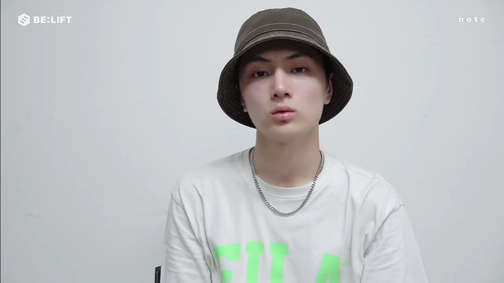 a young man wearing a hat and t - shirt