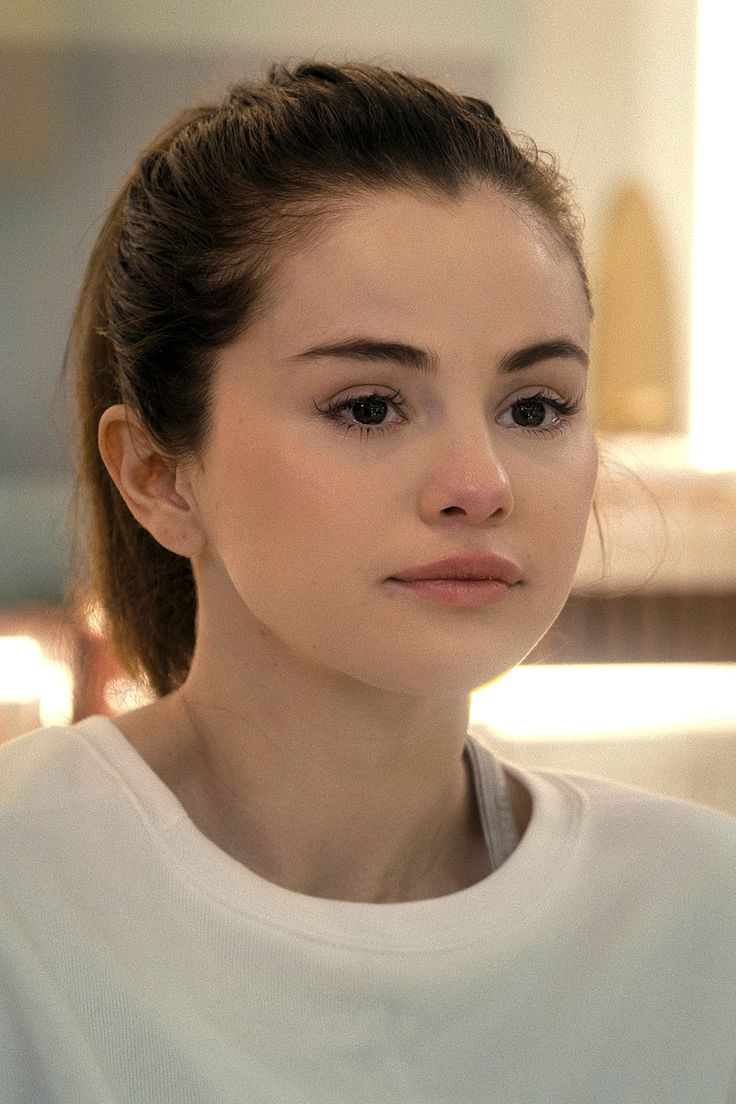 a woman is looking at the camera while wearing a white shirt