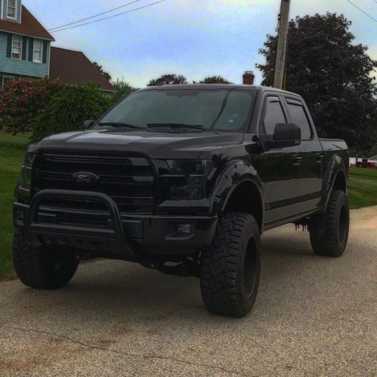 a black truck parked on the side of a road