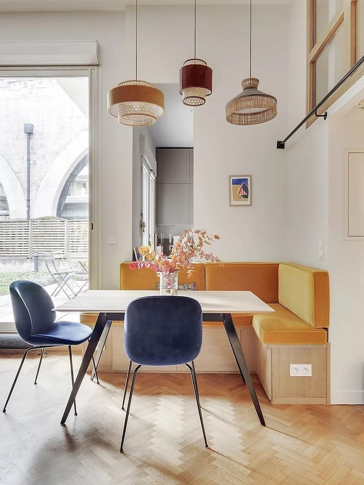 a dining room table with two chairs and a bench in front of a large window