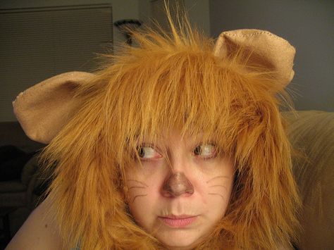 a woman with orange hair and cat ears on her head is looking at the camera