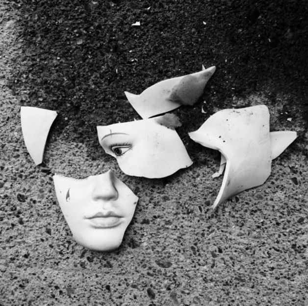 three pieces of plastic head are shown in black and white, with one piece missing from the face