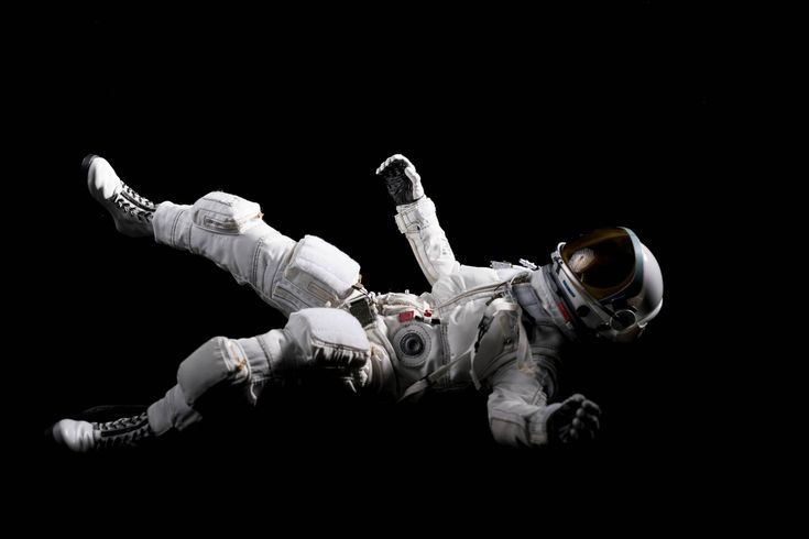 an astronaut floating in the air with his legs spread out and feet on one side