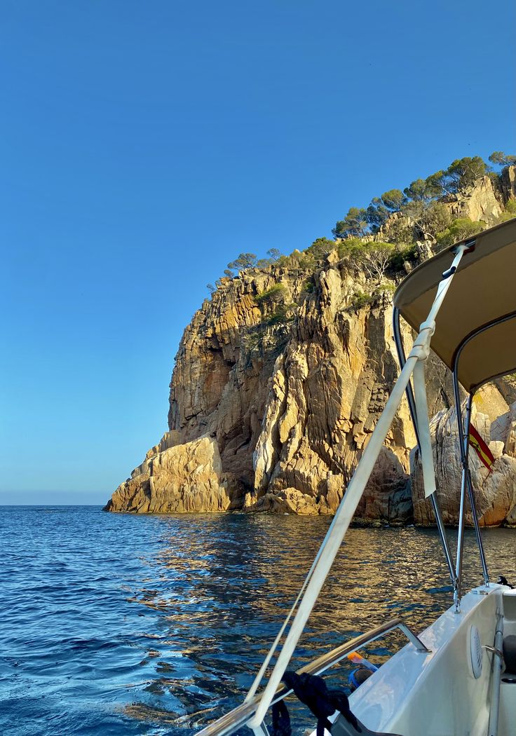 there is a boat in the water near some rocks