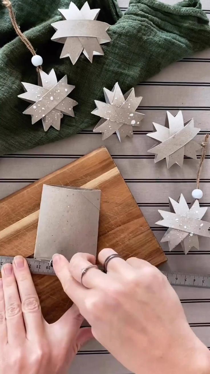 someone is cutting out some paper stars on a wooden board and measuring them with a tape