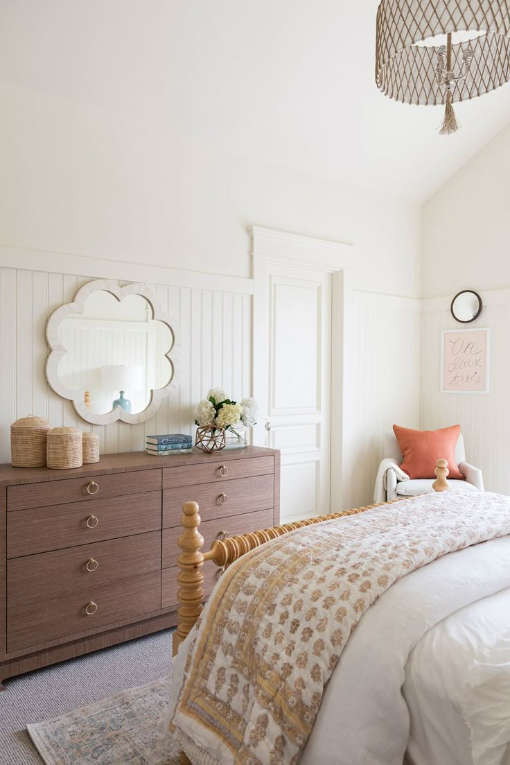 a bedroom with a bed, dresser and mirror on the wall next to each other