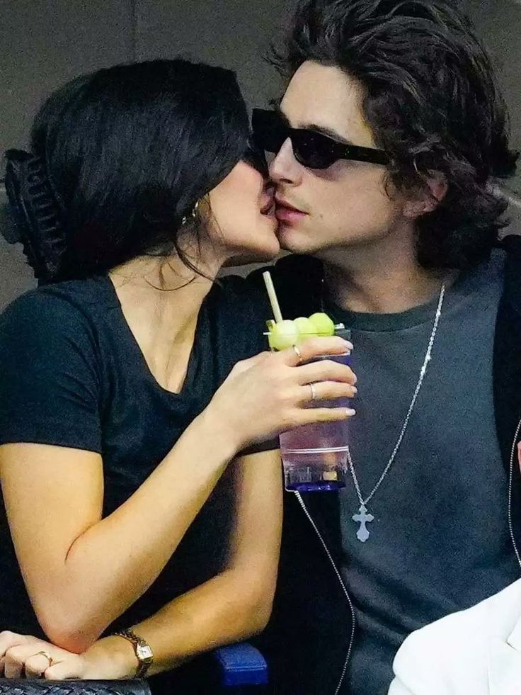 a man and woman kissing while holding an apple