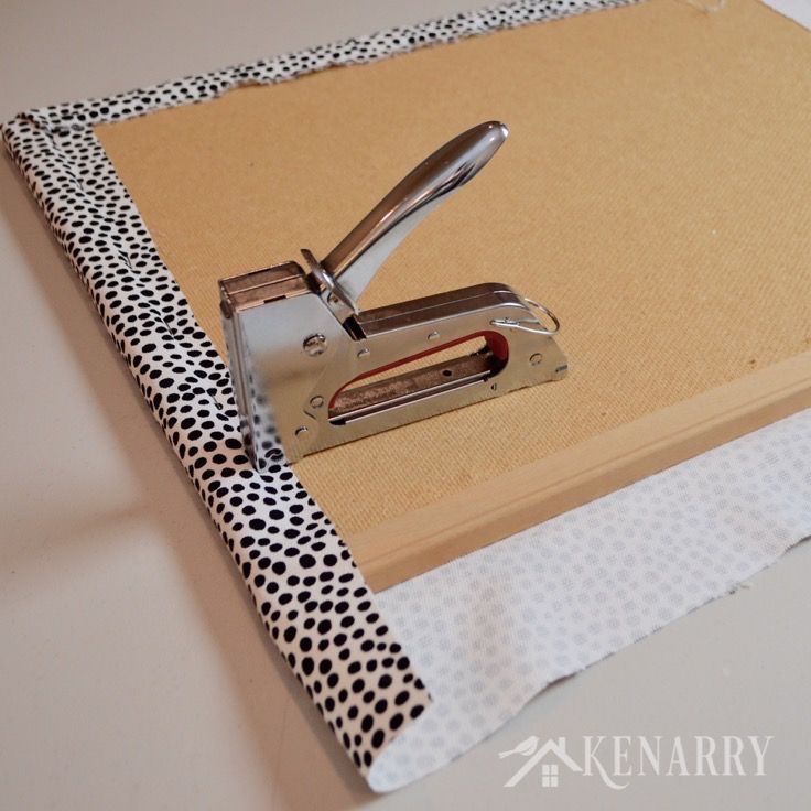 a pair of staplers on top of a binder with polka dot print fabric