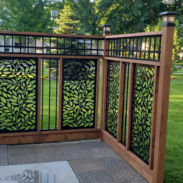 a wooden fence with an intricate design on the top and bottom part, in front of a grassy area