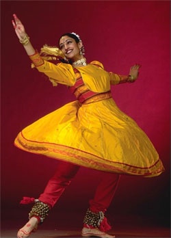 a woman in a yellow dress is dancing with her arms outstretched and legs spread out