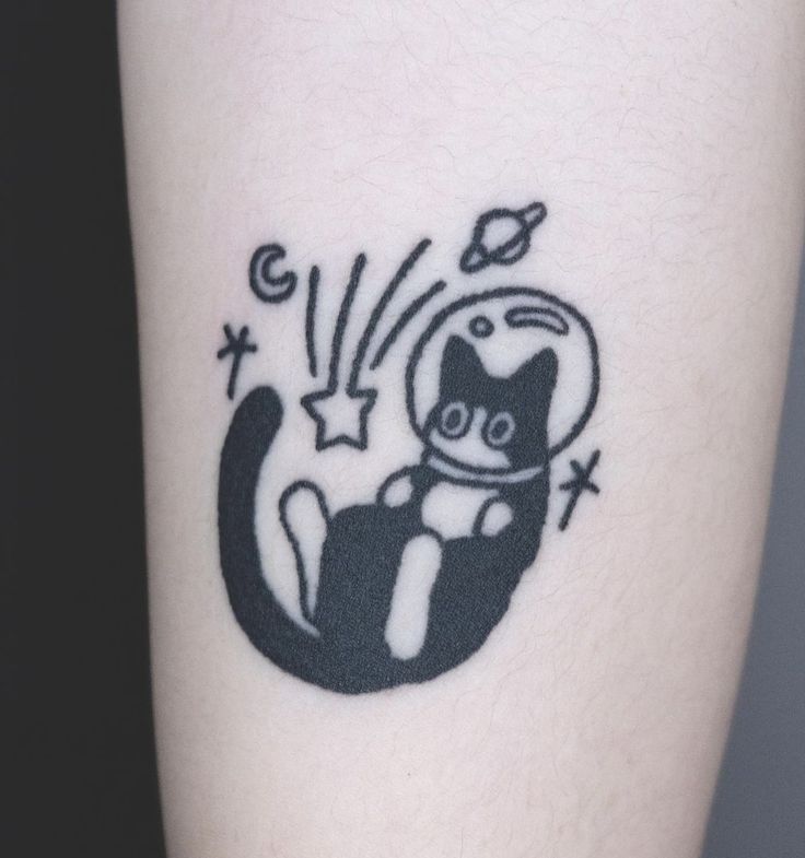 a black and white cat tattoo on the right leg, with stars coming out of it