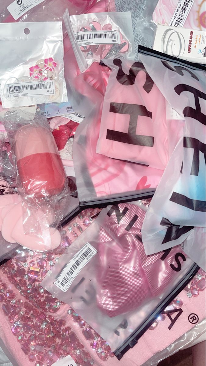 some pink items are laying out on the floor and covered in plastic bags with stickers