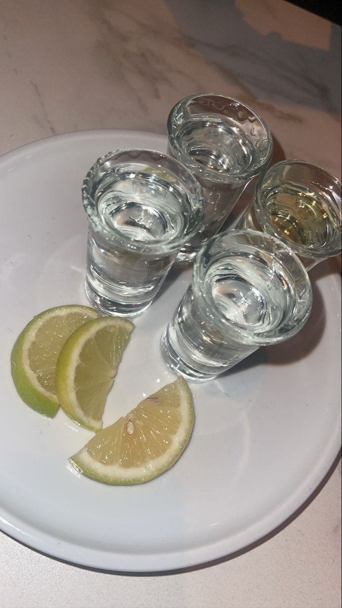 several glasses and slices of lemon on a white plate