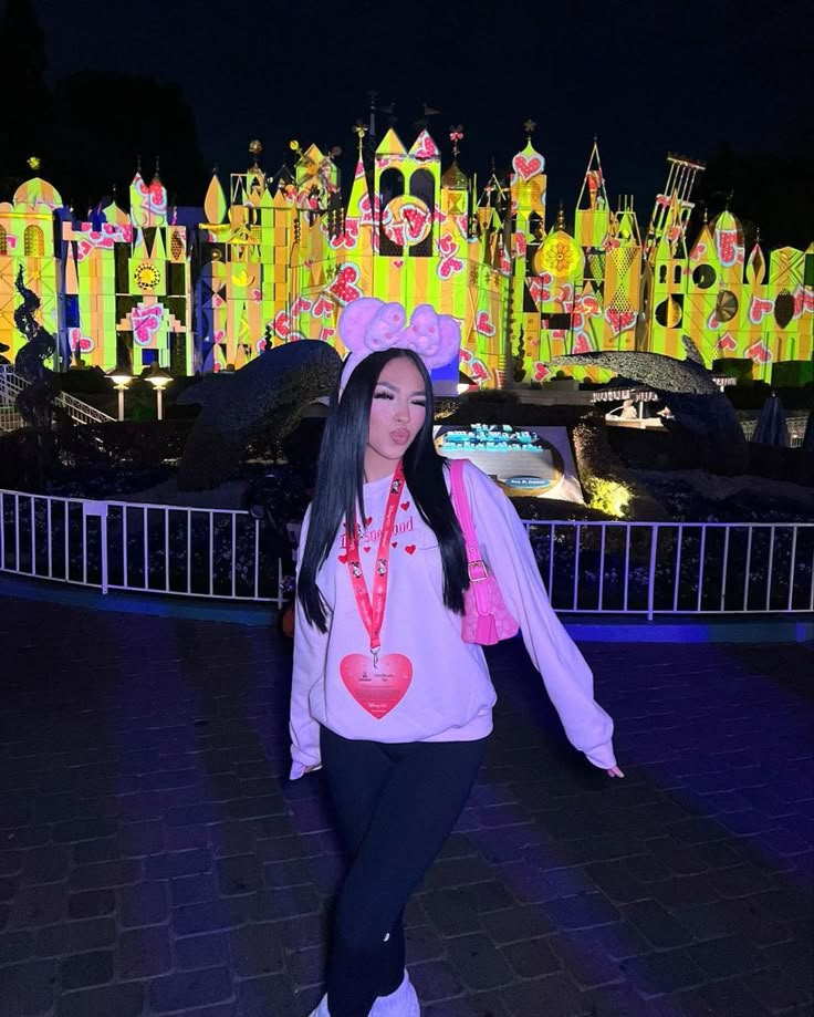 a woman standing in front of a castle at night