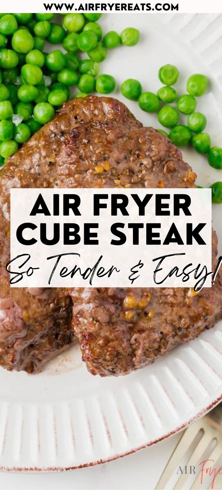 an air fryer cube steak on a white plate with green peas next to it