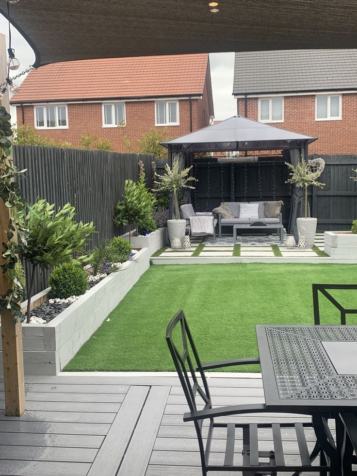 an outdoor patio area with grass and furniture