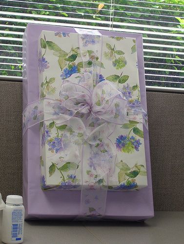 a wrapped present sitting on top of a table next to a bottle of lotion