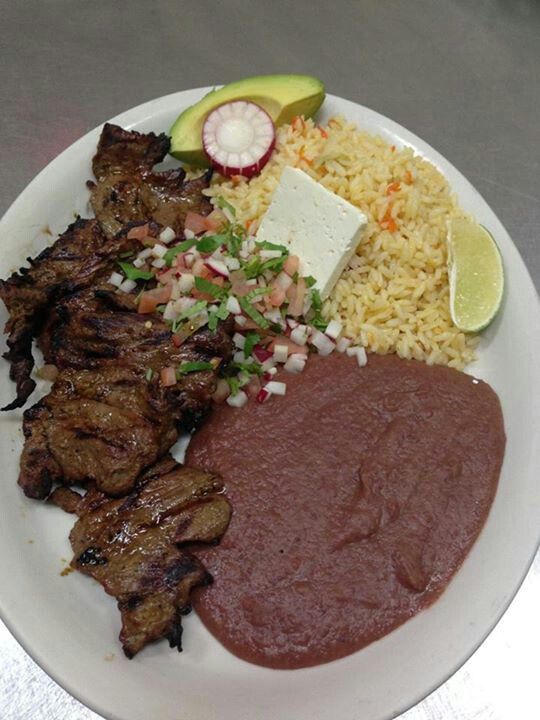 a white plate topped with meat, rice and veggies