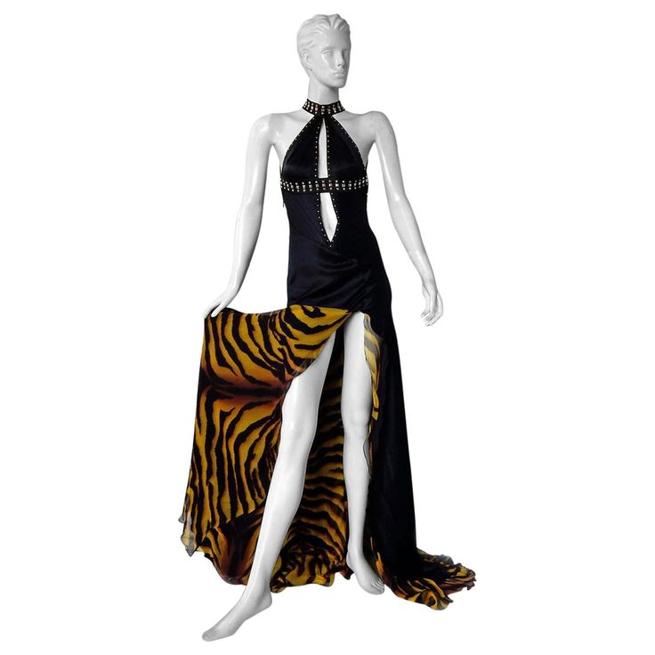 Early 2000 Versace cut-out halter gown fashioned in rich deep black silk. Boasts thigh high slit and plunging neckline. Trimmed with square faceted silvertone grommets. Bias cut with asymmetric open back with long full tiger print panel. Zipper closure. Uniquely designed and beautifully made. Size: 38; bust: to approx 30"; waist: 28"; hips: to approx 40"; length: 60+++ Condition: nwt; unworn Versace 2000s, Versace Fw22, Versace Vintage, Big Dresses, Vintage Runway, Versace Fashion, Halter Gown, Cindy Crawford, Gianni Versace