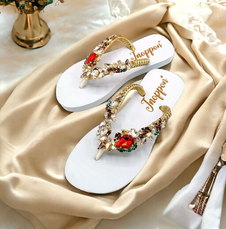 Description The beautiful rhinestone and customizable Flip Flops for the beach brides, bridesmaids, vacation, honeymoon or any occasion you desire to look gorgeous. Perfect in any outfit! Being unique and stunning on design, these flip flops must be your must-have item! The sandal is anti-slip, comfortable and durable as it is made from high quality rubber from the South of Thailand, where is famous for the best rubber tree. Moreover, the crystals are decorated on the sandal with effective adhesive glue and knitting threads by hand stitching. Don't worry when you walk on the beach or use it in the rainy season. For anyone who loves a real handmade product, don't miss it out! Product Description: - Thailand High-Quality Rubber Sole - Luxury Crystals/Rhinestones  - High-quality PU gold threa Summer Wedding Shoes With Rhinestones And Round Toe, Summer Wedding Shoes With Rhinestones, Open Toe Embellished Flip Flops For Party, Wedding Toe Post Sandals With Rhinestones, Summer Wedding Embellished Sandals, Gold Rhinestone Flip Flops For Vacation, Elegant Gold Flip Flops For The Beach, Elegant Gold Flip Flops For Beach, Elegant Party Flip Flops With Open Toe