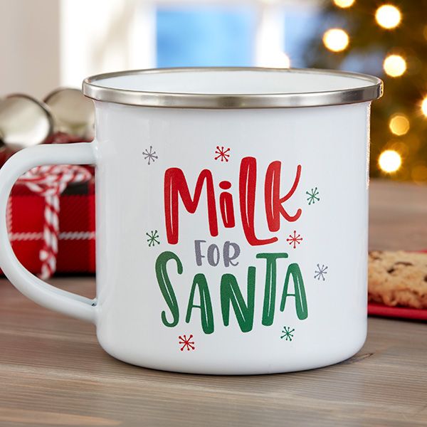 a white coffee mug with the words milk for santa on it next to some cookies