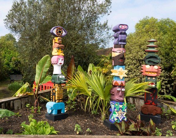 two totems in the garden with plants and trees