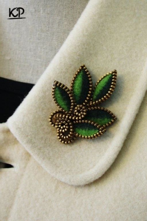 a green brooch sitting on top of a white napkin