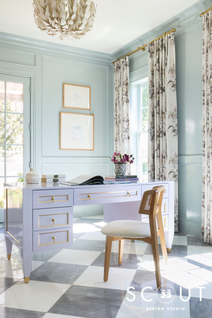 a desk and chair in a room with curtains on the window sill, chandelier hanging from the ceiling