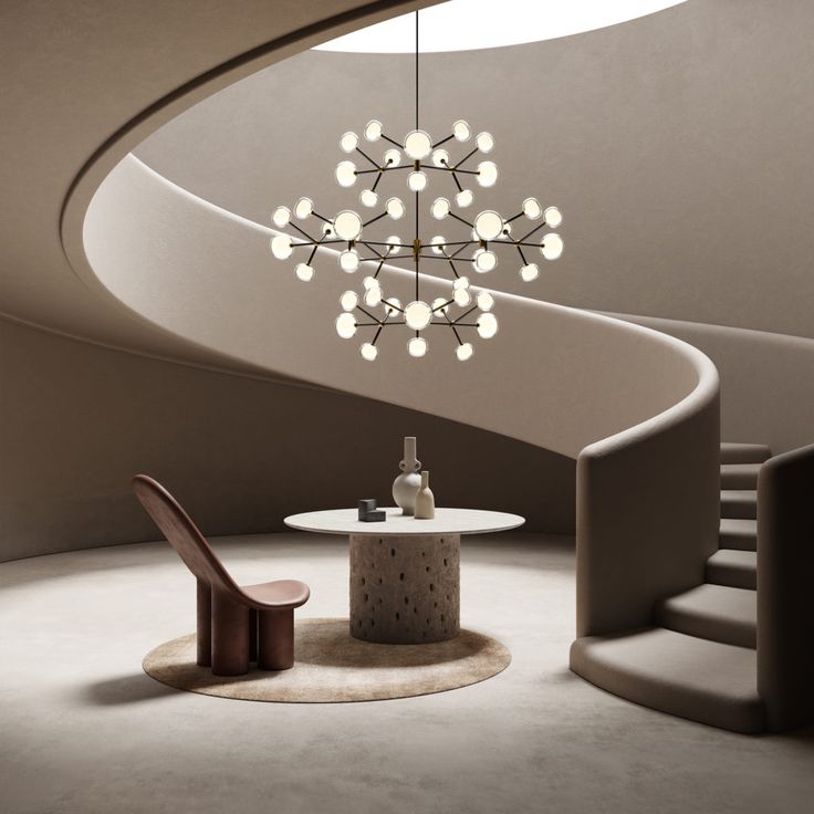 a modern chandelier hanging from the ceiling in a room with stairs and table