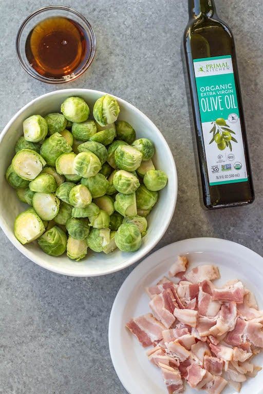 brussel sprouts, bacon and olive oil are on the counter next to a bowl of brussel sprouts