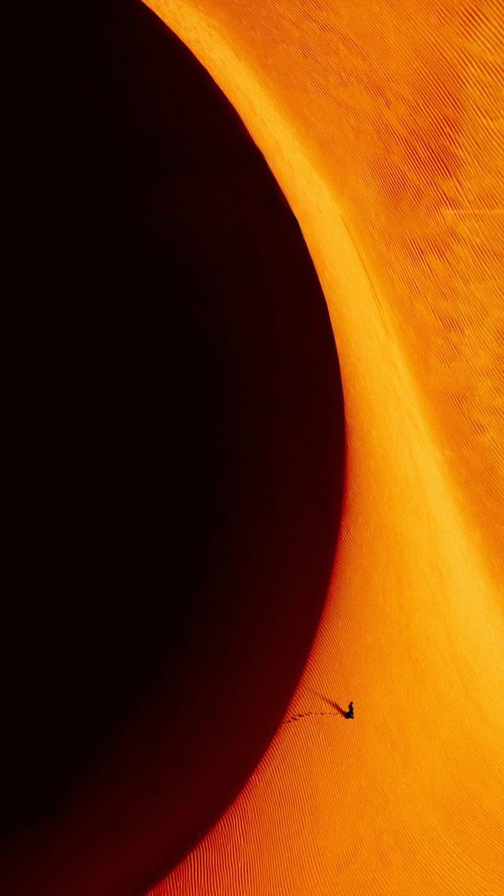 a person is flying through the air in an orange desert like area that appears to be made of sand