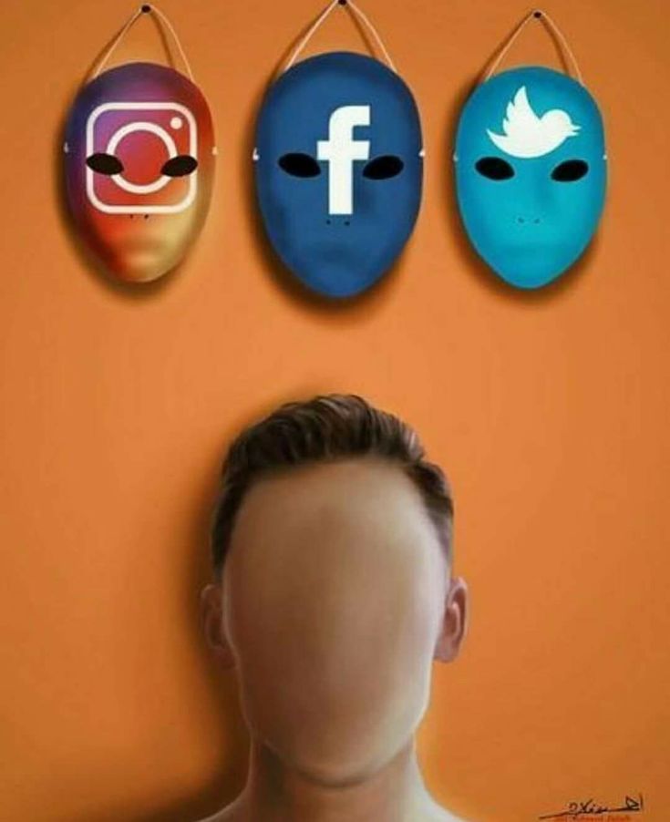 the man is standing in front of three masks with facebook logos on them, and one has his head up