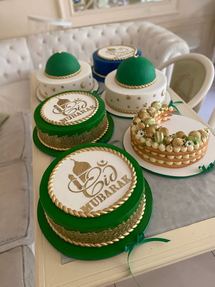 a table topped with plates and cakes covered in green frosting next to a white couch