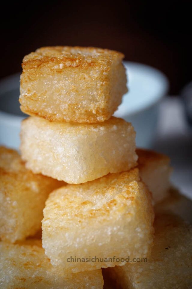 some sugar cubes stacked on top of each other in front of a white bowl