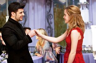 a woman in a red dress and a man in a black suit are dancing together