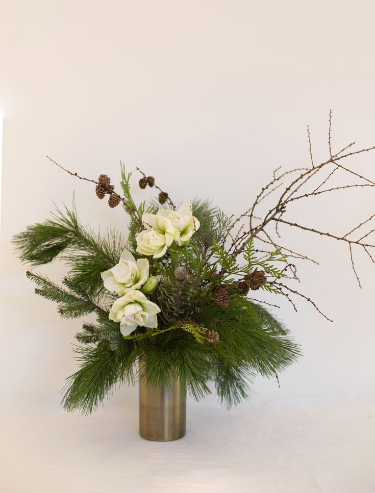 a vase filled with white flowers and greenery