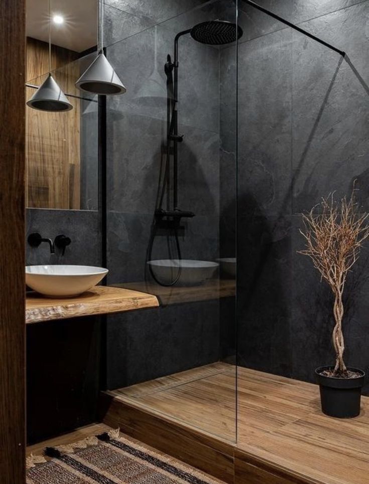 a bathroom with a glass shower door and wooden counter top next to a white sink