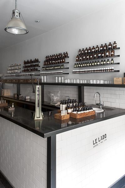 an empty bar with bottles on the wall and lights hanging above it in a restaurant