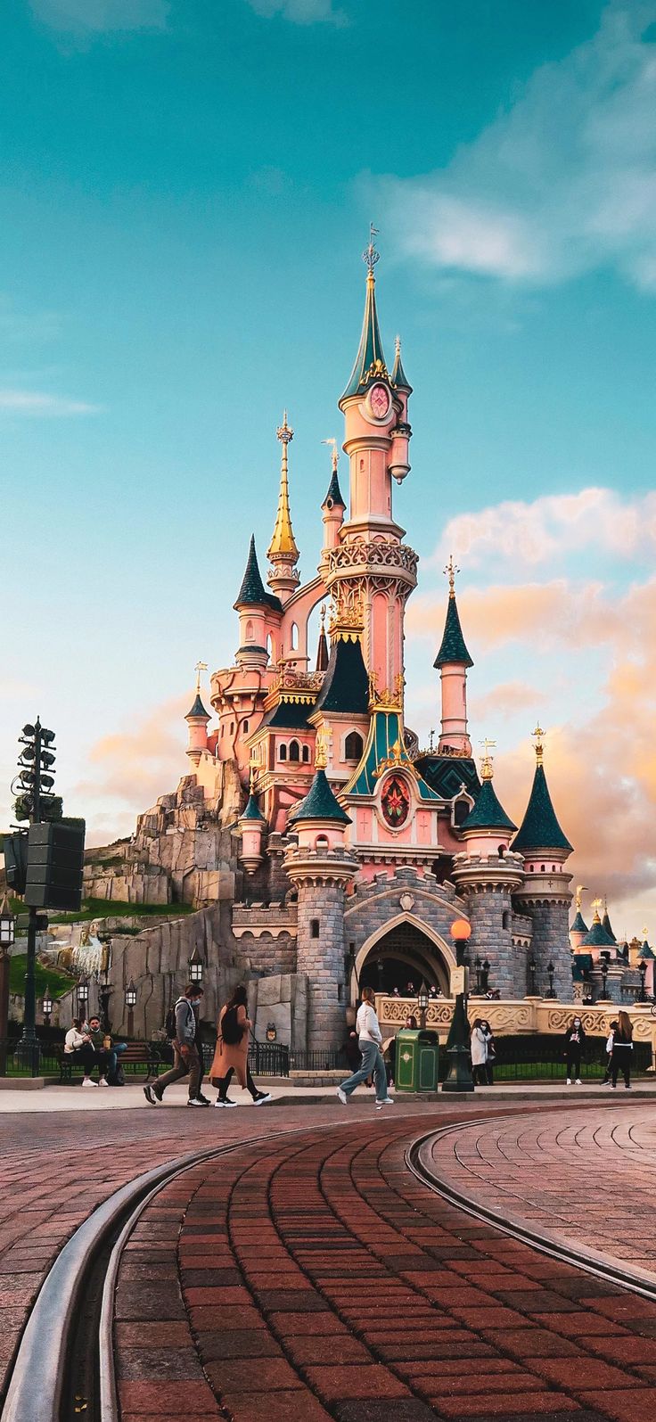 people are walking around in front of a castle