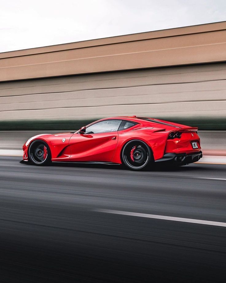 a red sports car driving down the road