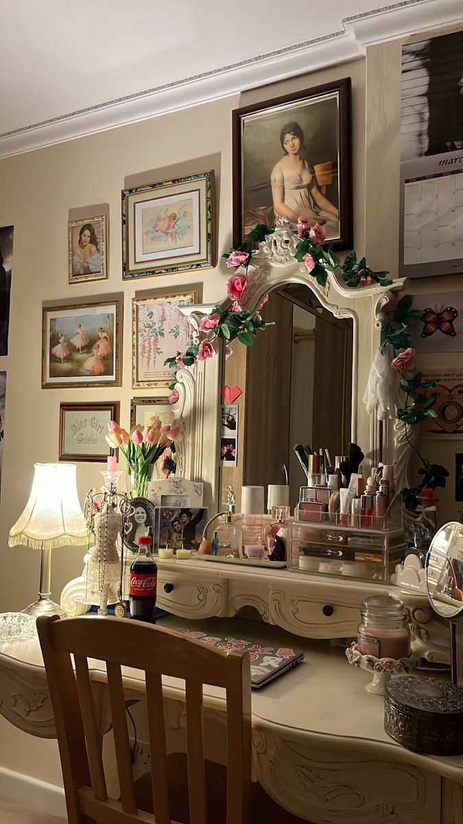 a desk with a mirror, chair and pictures on the wall