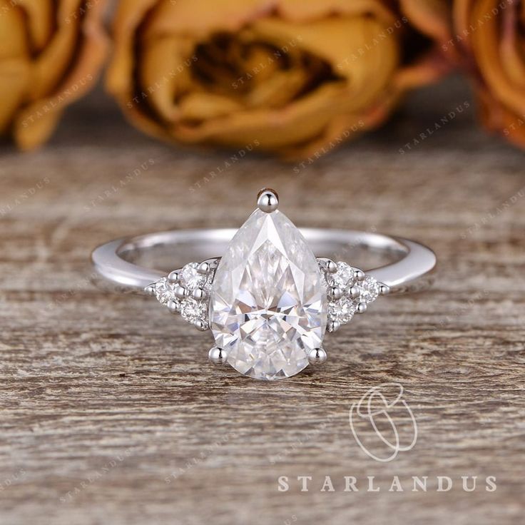 a pear shaped diamond engagement ring with three side stones