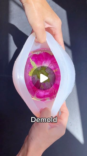 a person holding a pink flower in their hand with the words demold on it