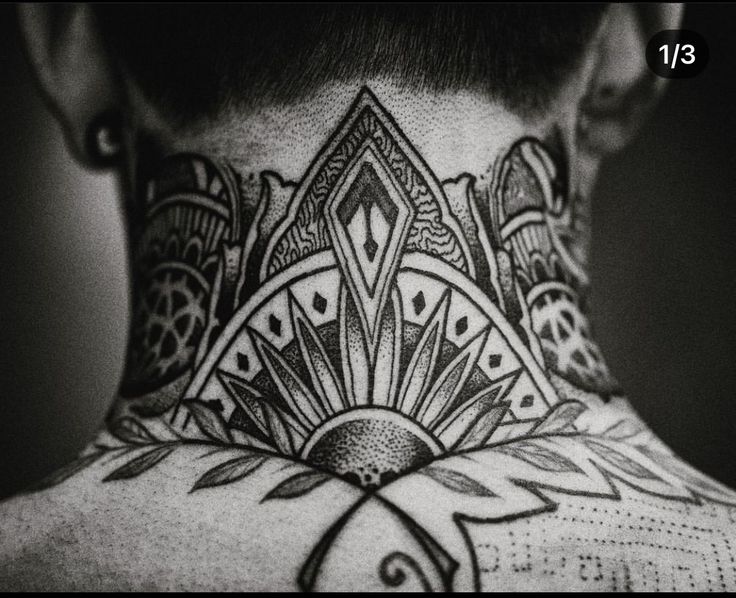 black and white photograph of a man's back neck with tattoos on his neck