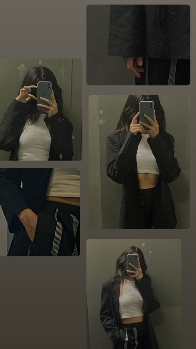 a woman taking a selfie in front of a mirror with her cell phone and jacket over her shoulders