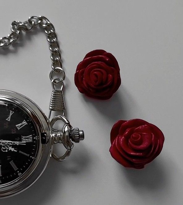 a red rose is sitting next to an open pocket watch